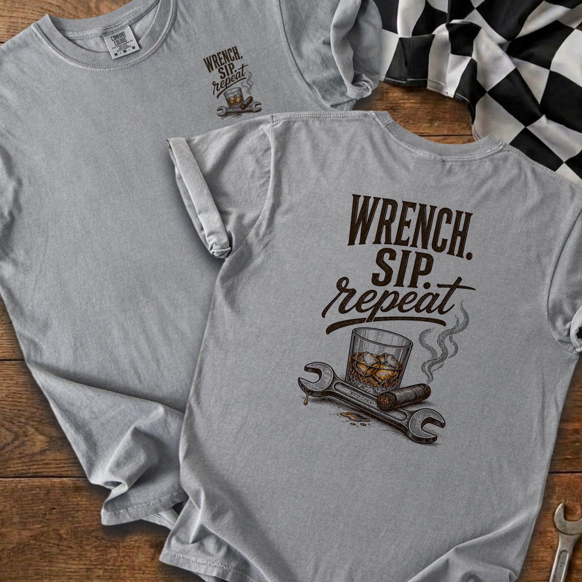 Gray t-shirt with "Wrench. Sip. Repeat." slogan and illustration of whiskey, cigar, and tools.