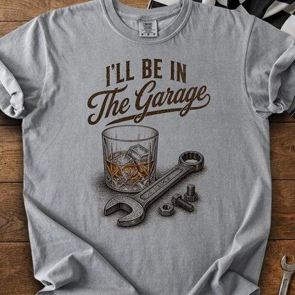 Gray t-shirt with "I'll be in the Garage" text, whiskey glass, wrench, and nuts.