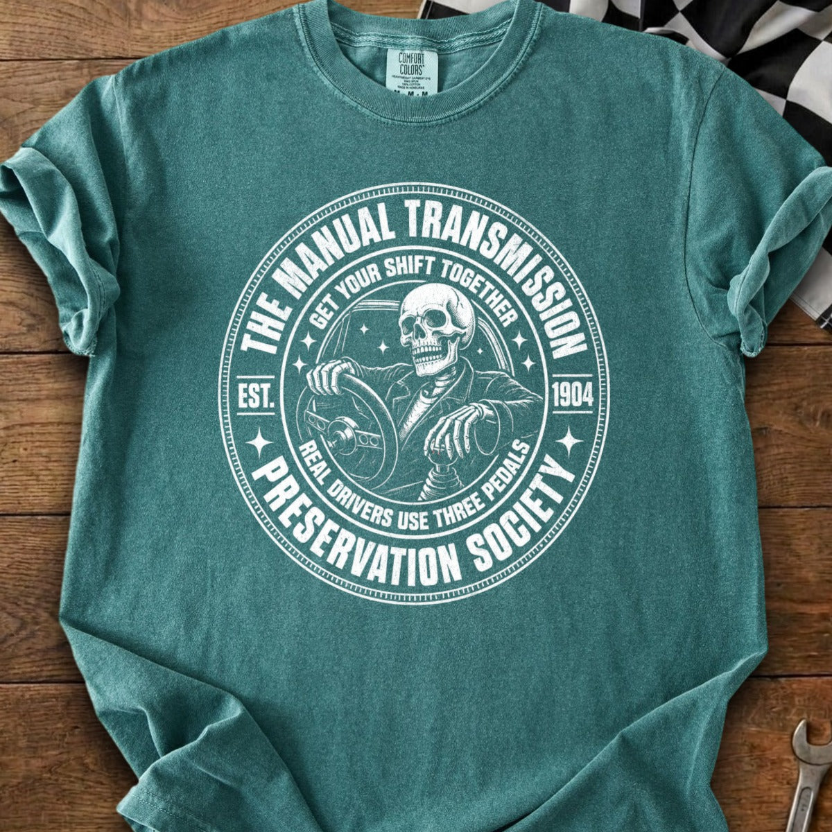 Skeleton driving with "The Manual Transmission Preservation Society" graphic.
