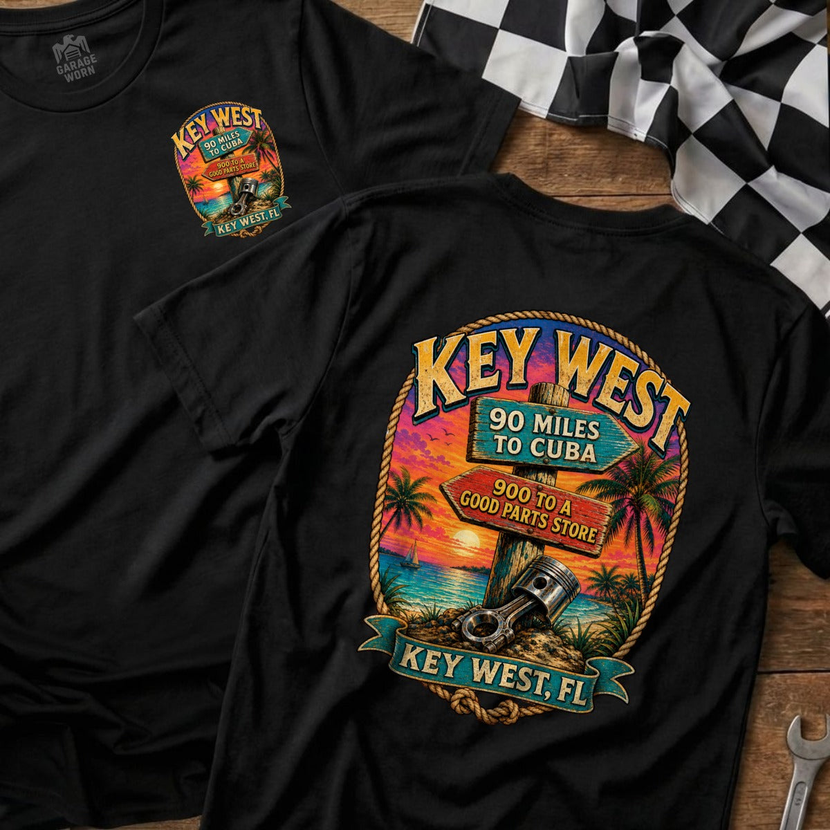 Black t-shirt with Key West sunset graphic and piston, reads "90 miles to Cuba" and "900 to a good parts store".