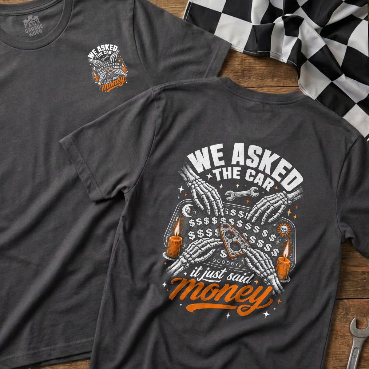 Dark grey t-shirt with skeleton hands using a ouija board with "money" graphic.