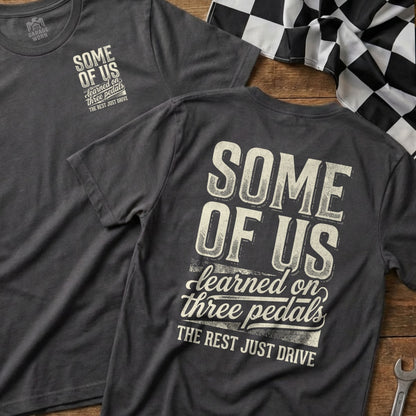 Two t-shirts with "Some of us learned on three pedals" text.