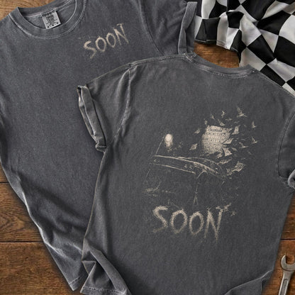 Dark grey t-shirts with "SOON" graphic and a calendar with birds.