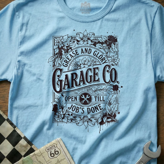Light blue t-shirt with "Garage Co." logo, flowers, and "Grease and Glory" text.