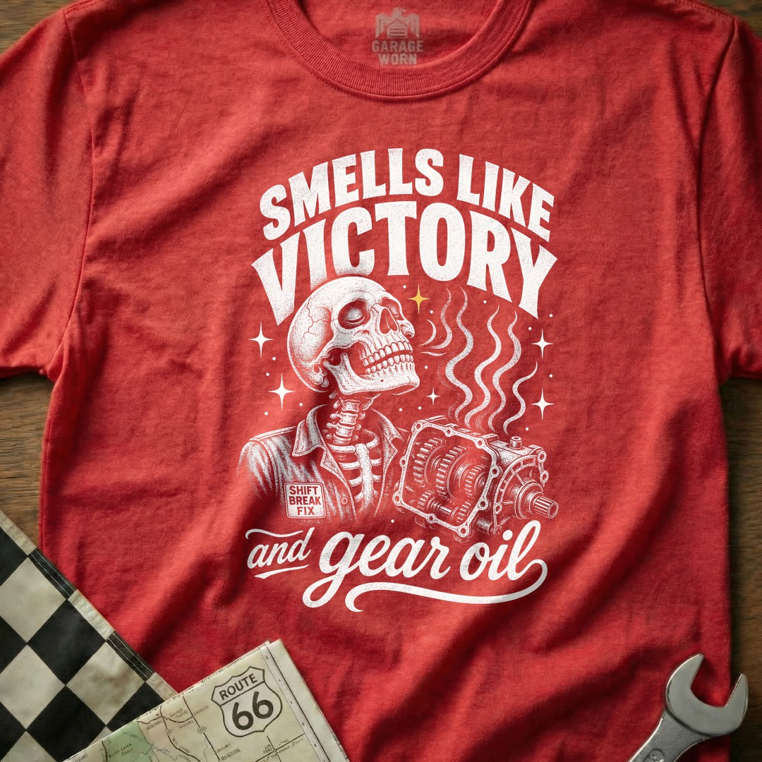 Red t-shirt with skeleton holding transmission, "Smells Like Victory and Gear Oil" text.