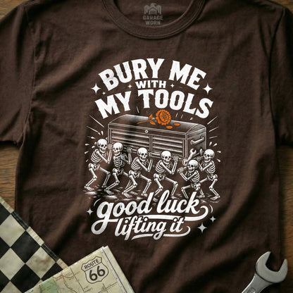 T-shirt with skeletons carrying a toolbox and text "Bury me with my tools, good luck lifting it."