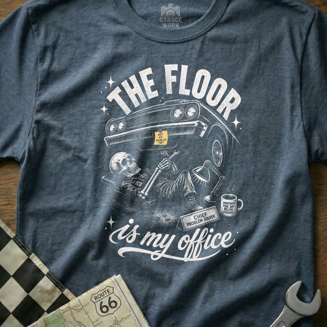 Skeleton mechanic under car with text "The floor is my office".