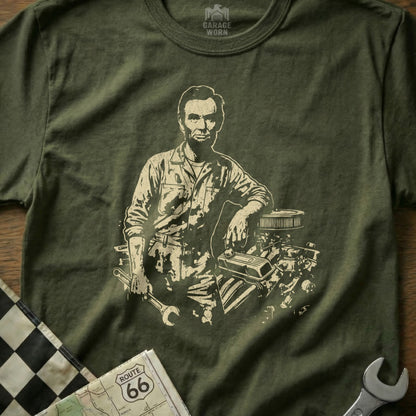 Abraham Lincoln leaning on engine parts with wrench, on a t-shirt.