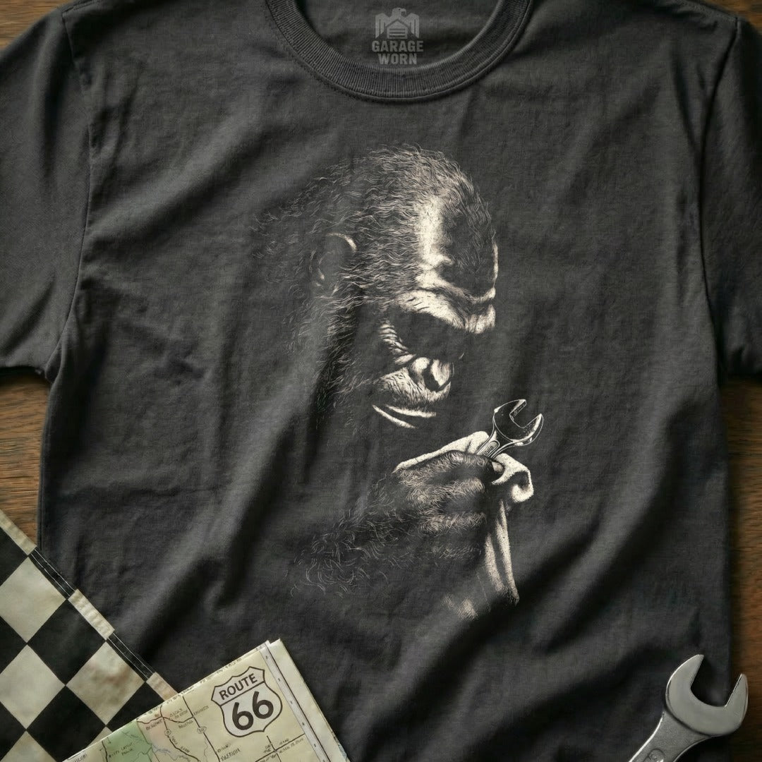 T-shirt with a black and white illustration of a gorilla holding a wrench.