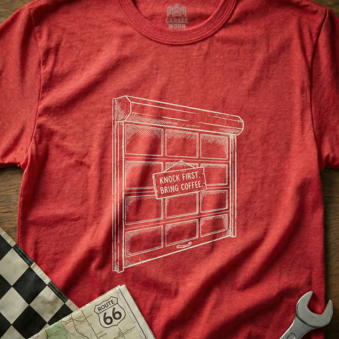 Red t-shirt with a garage door graphic that reads "Knock First. Bring Coffee."