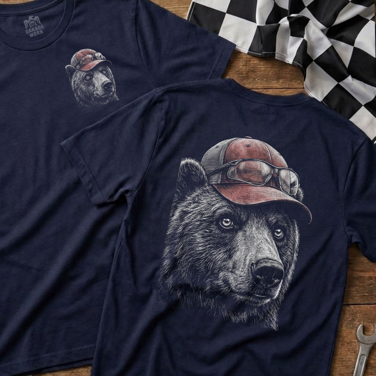 Bear wearing a baseball cap and glasses on a navy t-shirt.