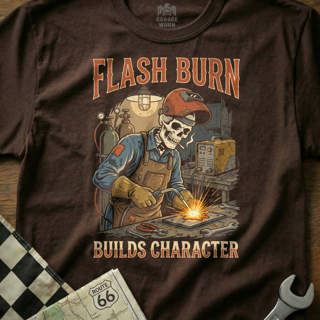 Skull welder with "Flash Burn Builds Character" text on brown t-shirt.