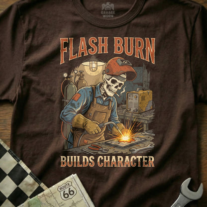 Skull welder with "Flash Burn Builds Character" text on brown t-shirt.
