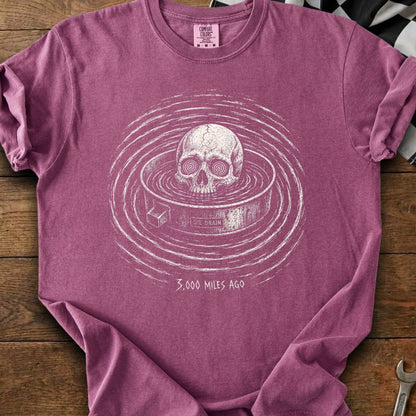 Skull in oil drain with "3,000 Miles Ago" text on maroon t-shirt.