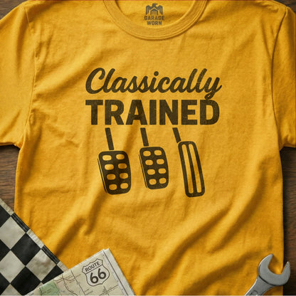 Yellow t-shirt with "Classically Trained" text and car pedals.