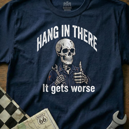 Skeleton mechanic giving thumbs up, wearing "Hang in There It Gets Worse" shirt.