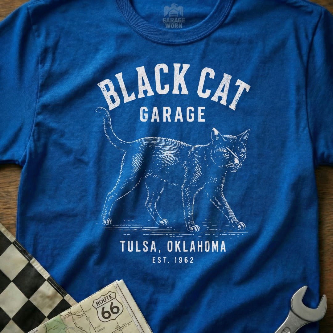 Blue t-shirt with white text "BLACK CAT GARAGE TULSA, OKLAHOMA EST. 1962" and a cat illustration.