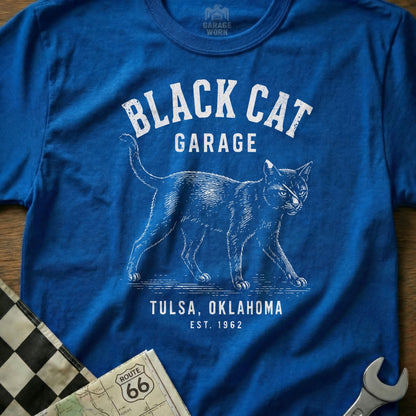 Blue t-shirt with white text "BLACK CAT GARAGE TULSA, OKLAHOMA EST. 1962" and a cat illustration.