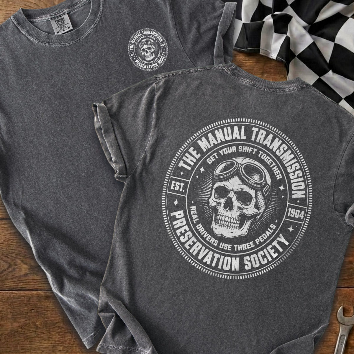 Dark gray t-shirt with a skull and goggles logo that reads "The Manual Transmission Preservation Society".