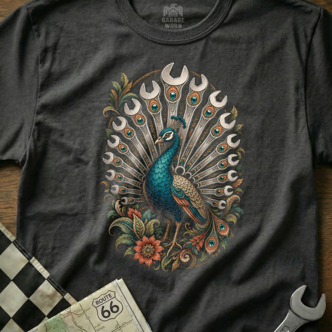 Peacock with fan of wrenches and floral accents on a dark t-shirt.