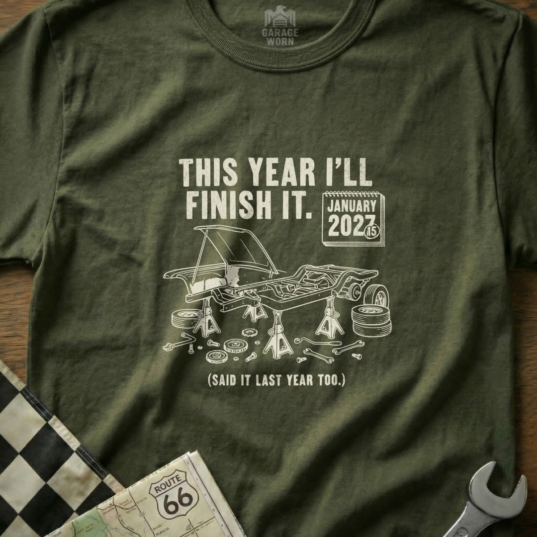 Olive green t-shirt with "This Year I'll Finish It. January 2027" and car graphic.