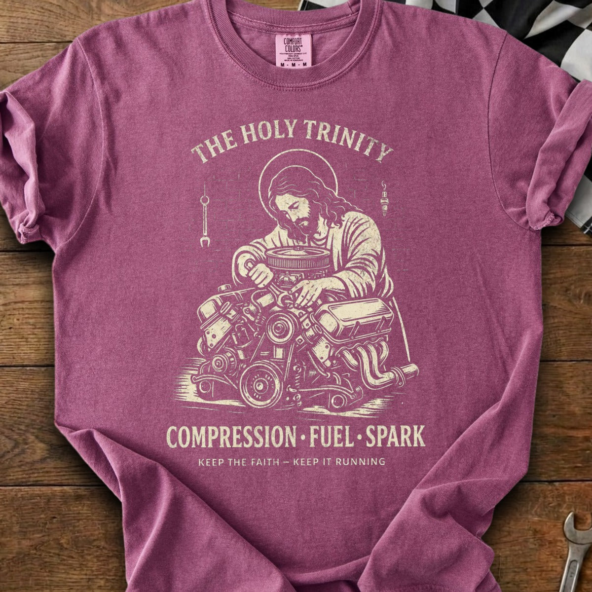 Jesus working on an engine with text "The Holy Trinity Compression Fuel Spark".