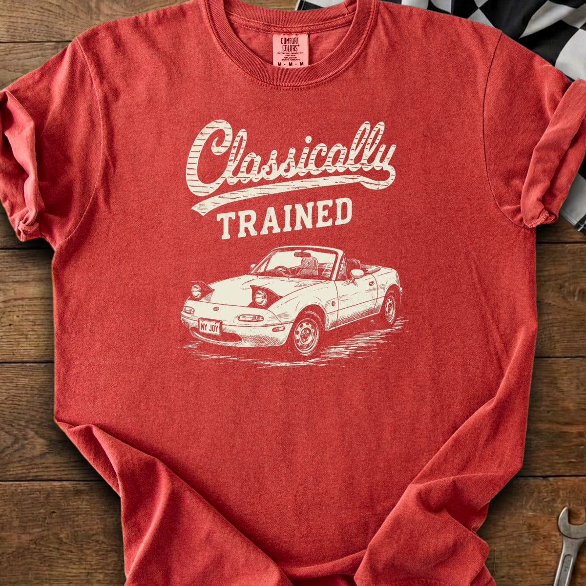 Red t-shirt with white text "Classically TRAINED" and a drawing of a convertible car.