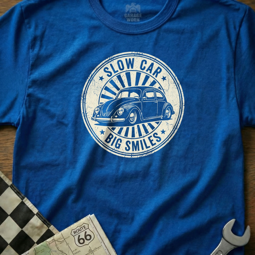 Blue t-shirt with a circular graphic of a vintage Volkswagen Beetle and "Slow Car Big Smiles".