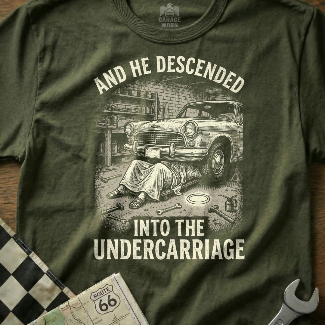 T-shirt graphic: man working under car, text "AND HE DESCENDED INTO THE UNDERCARRIAGE".