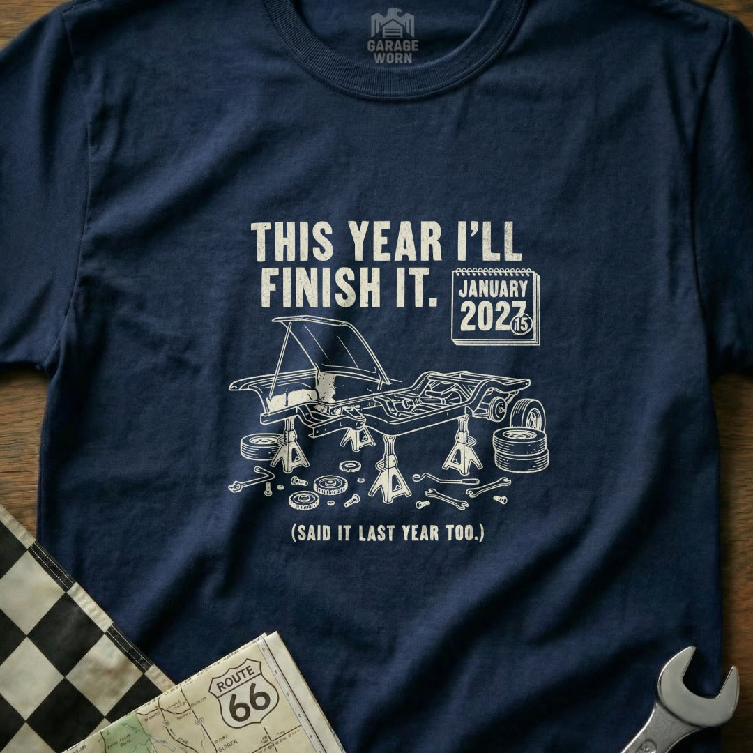 T-shirt with car under repair, "This year I'll finish it." text.
