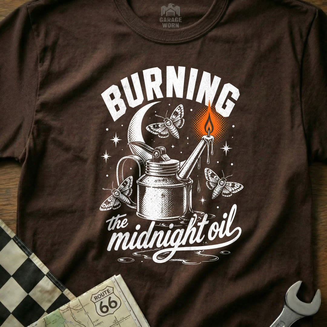 T-shirt graphic with moths, oil can, candle flame, and text "Burning the midnight oil".