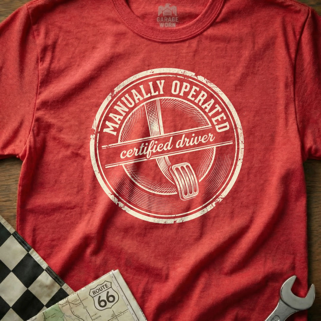 Red t-shirt with "Manually Operated Certified Driver" text and gas pedal graphic.