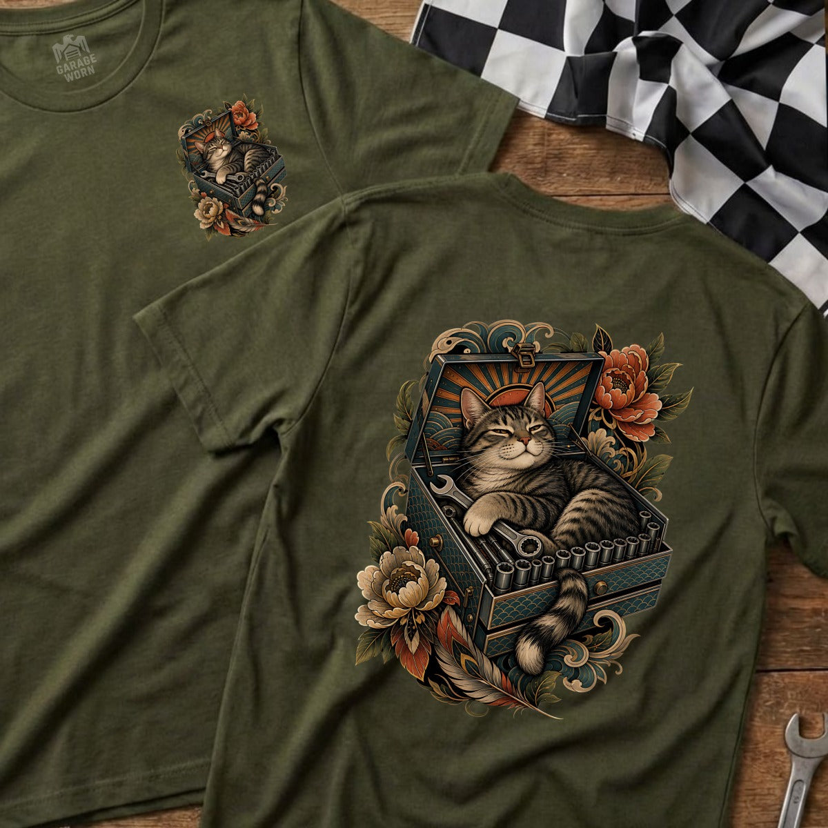 Green t-shirt with a tabby cat relaxing in a toolbox surrounded by flowers.