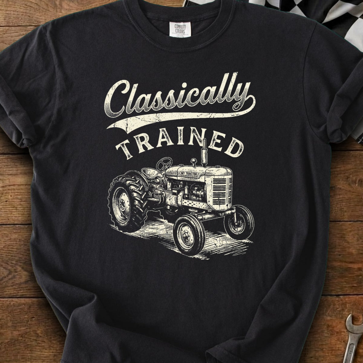 Black t-shirt with cream graphic of a vintage tractor and text "Classically TRAINED".