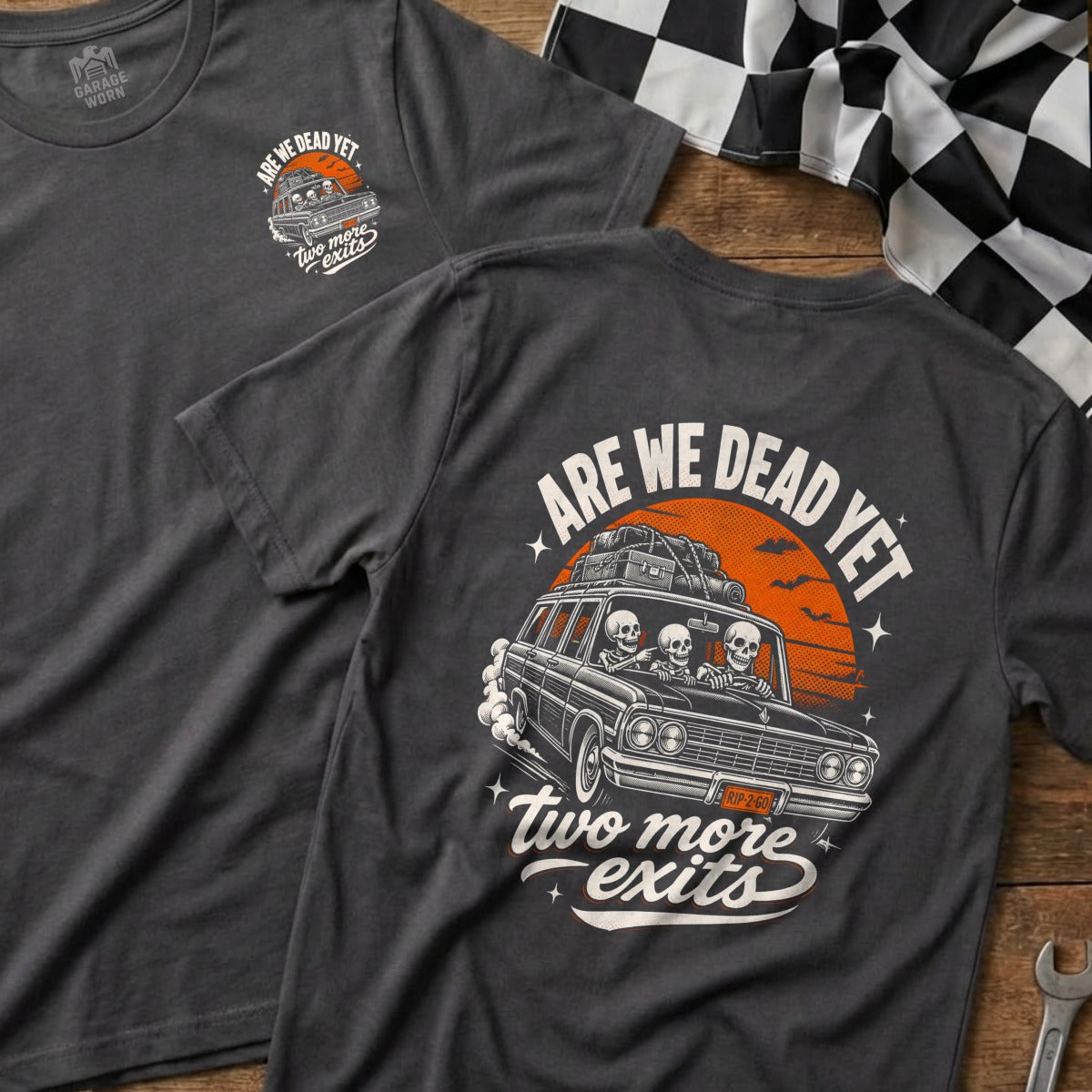 Dark grey t-shirt with "ARE WE DEAD YET" and skeletons in a car.