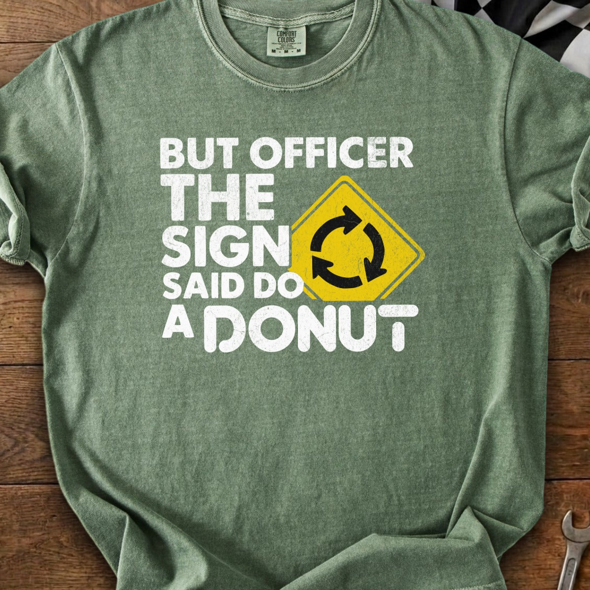 Green t-shirt with white text: "BUT OFFICER THE SIGN SAID DO A DONUT" and a yellow traffic sign.