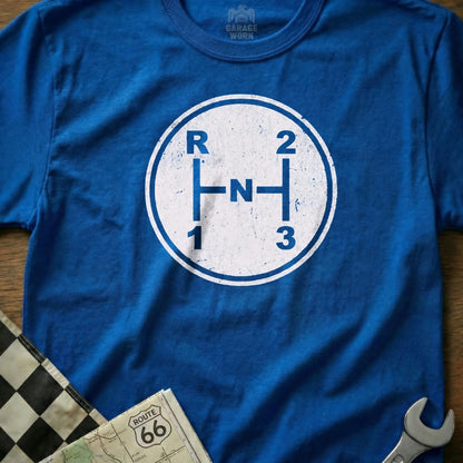 Blue t-shirt with vintage manual transmission shifter graphic and "Garage Worn" logo.