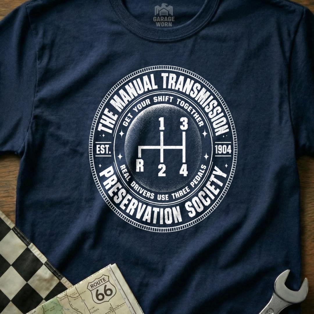 Navy shirt with "The Manual Transmission Preservation Society" graphic and gear shifter.