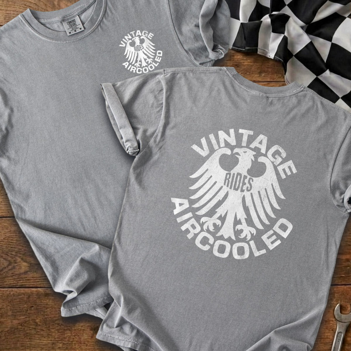 Two grey t-shirts displayed with a distressed white eagle graphic and text.