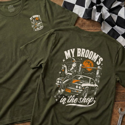 Green t-shirt with "My Broom's in the shop" graphic featuring a witch and a car.