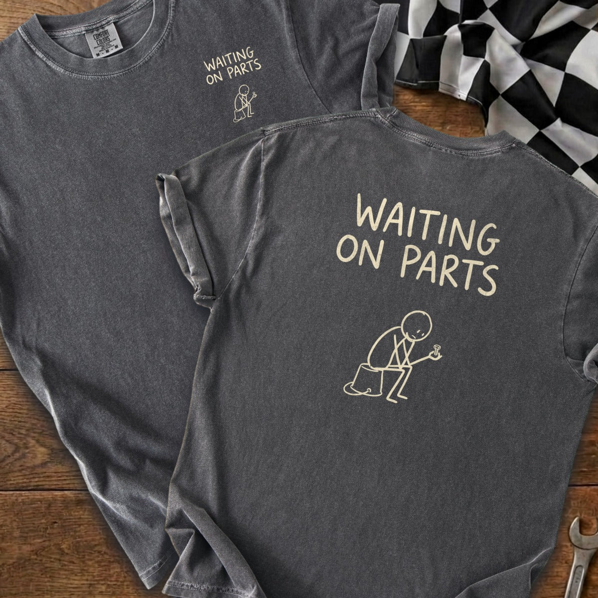 Dark gray t-shirt with "WAITING ON PARTS" text and a stick figure holding a part.