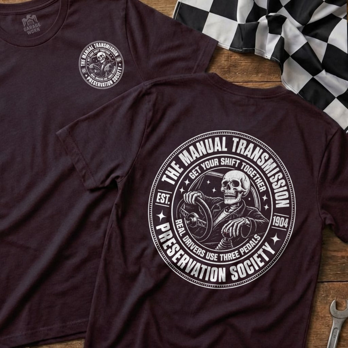 Dark t-shirt with "The Manual Transmission Preservation Society" circular graphic featuring a skeleton driving.