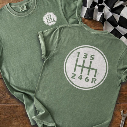Green t-shirt with a white manual transmission shift pattern graphic and checkered flag.