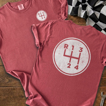 Crimson t-shirts featuring a white circular graphic of a manual transmission shift pattern.