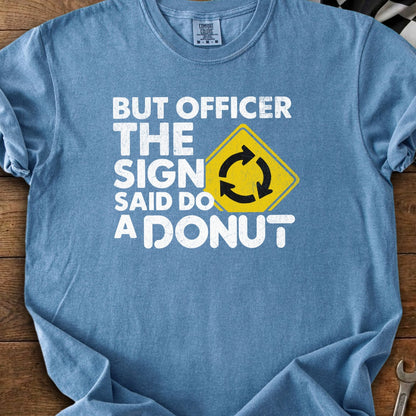 Blue t-shirt with white text: "BUT OFFICER THE SIGN SAID DO A DONUT".