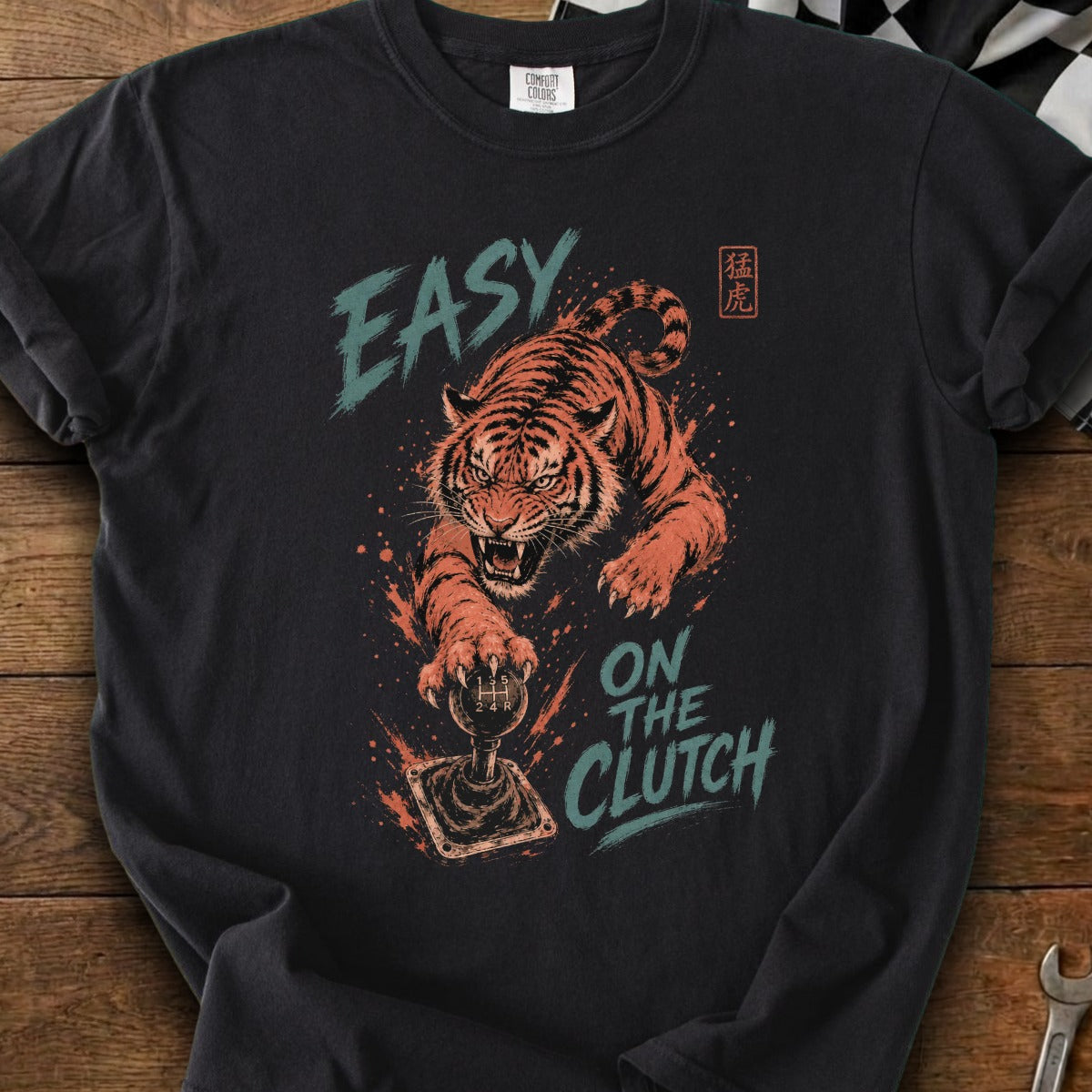 T-shirt with roaring tiger paw on a manual stick shift and text "EASY ON THE CLUTCH".