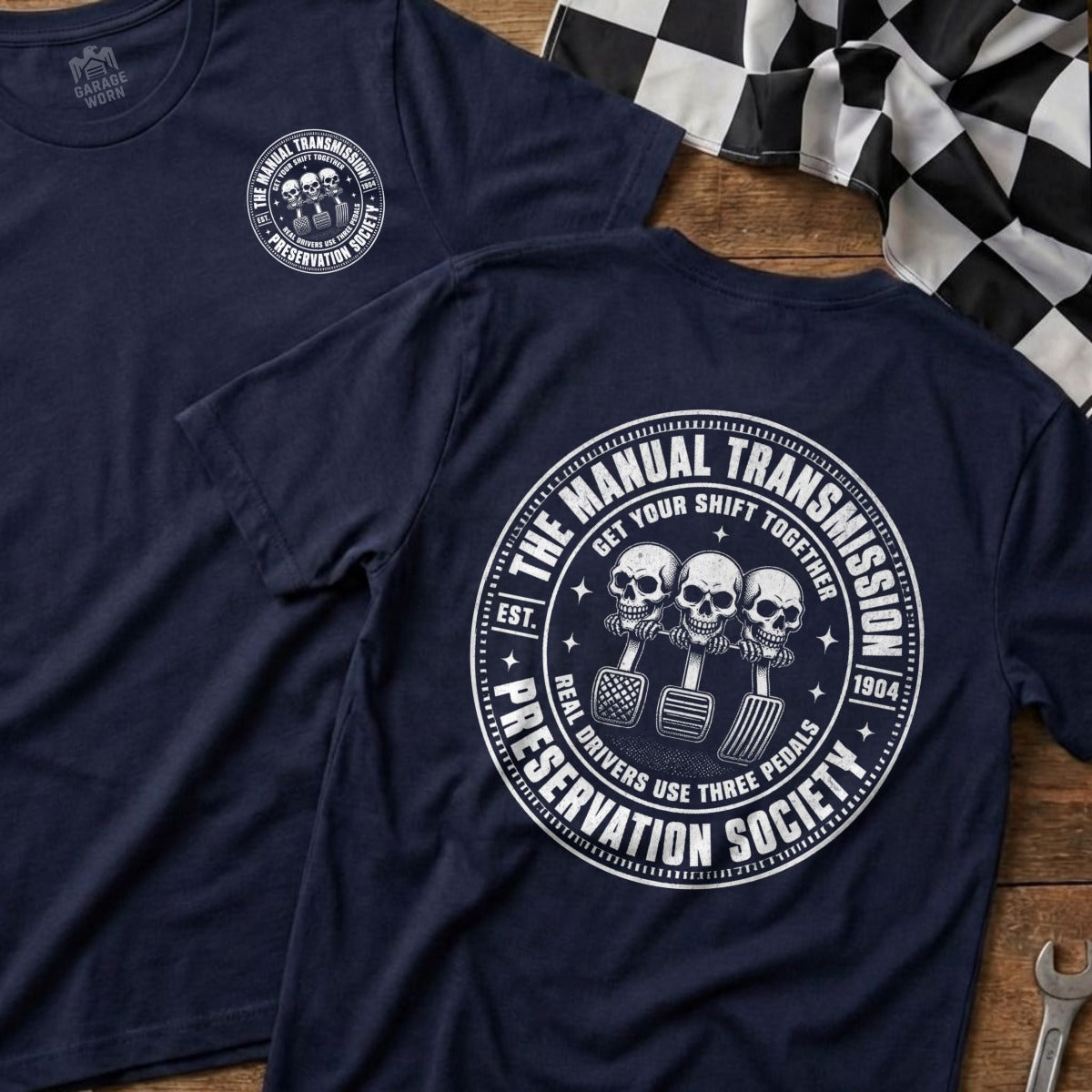 Navy t-shirt with circular graphic featuring skulls on gear shift, pedals, and text.