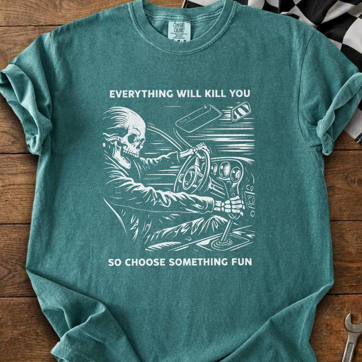 T-shirt with skeleton driving car graphic and text "EVERYTHING WILL KILL YOU SO CHOOSE SOMETHING FUN".