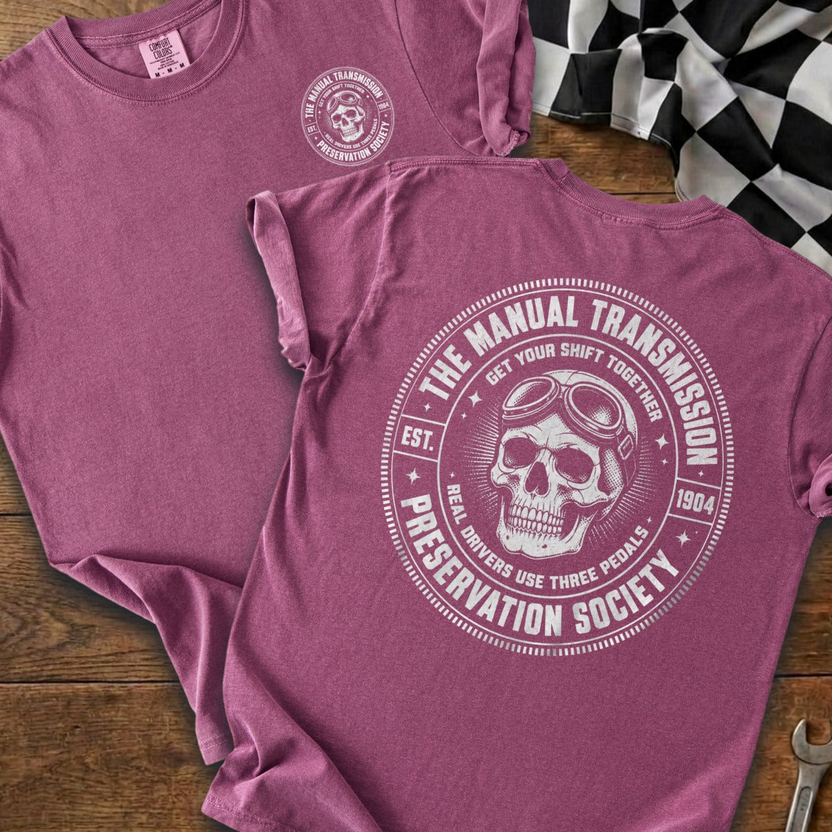 Maroon t-shirt with circular graphic of skull wearing goggles and text "The Manual Transmission Preservation Society".