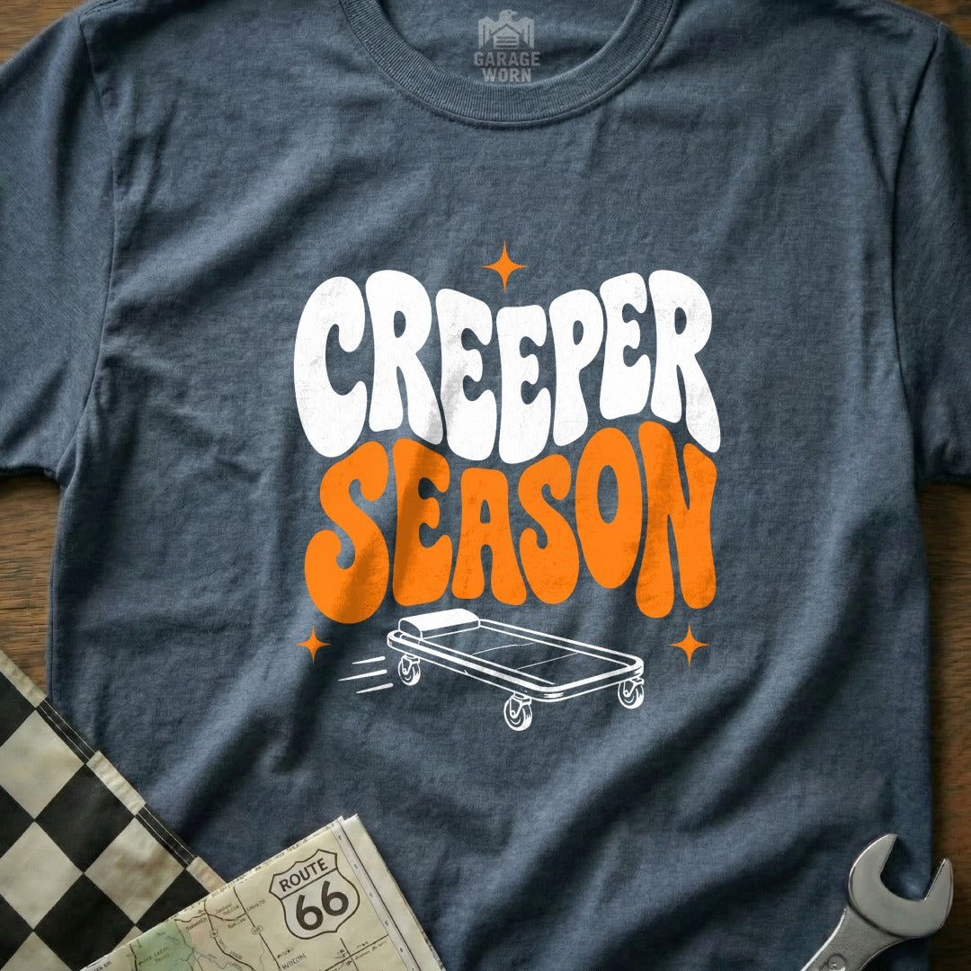 Dark gray t-shirt with white and orange "Creeper Season" text and rolling creeper graphic.